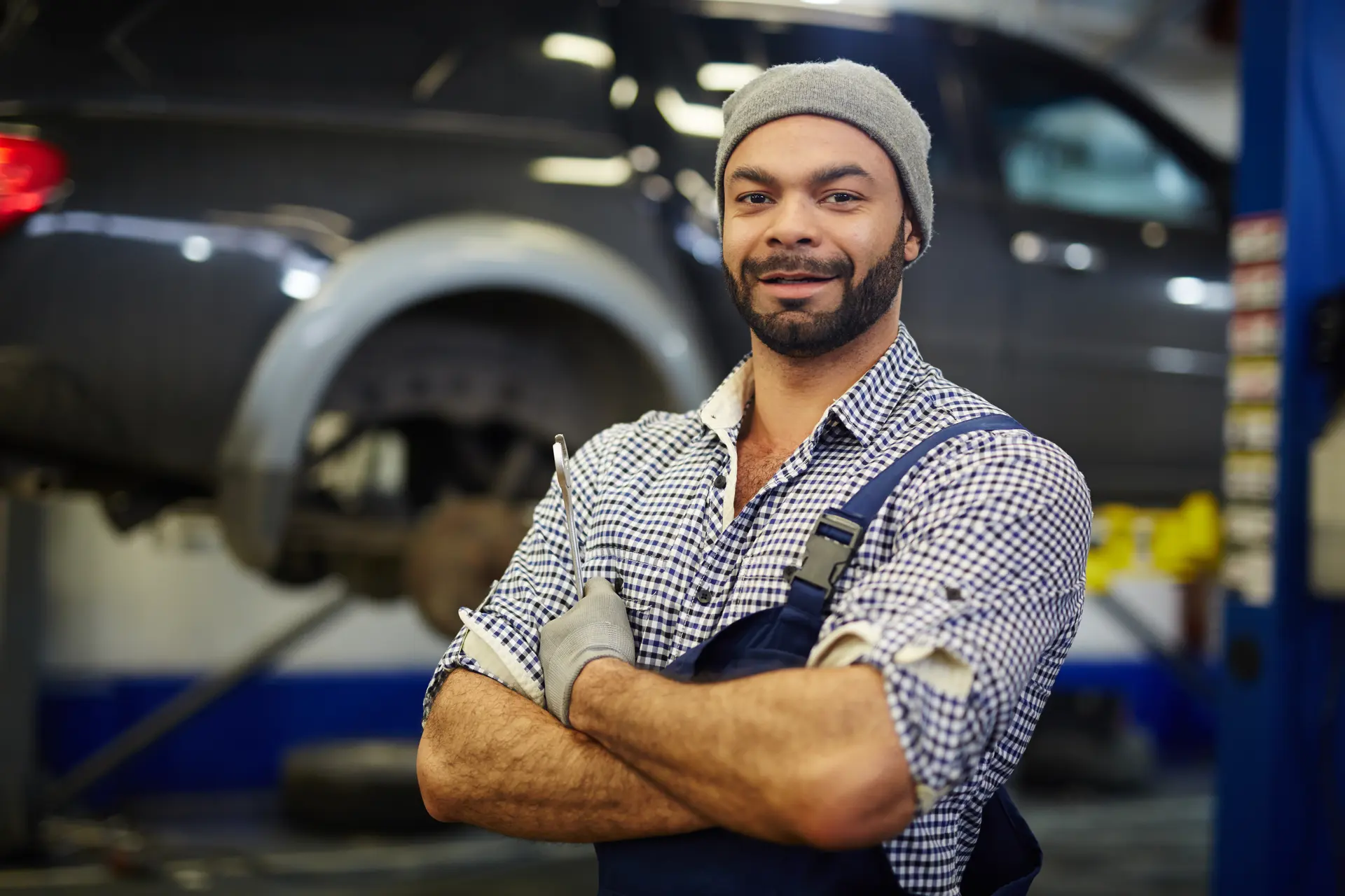 A repair technician in a workshop with his arms folded