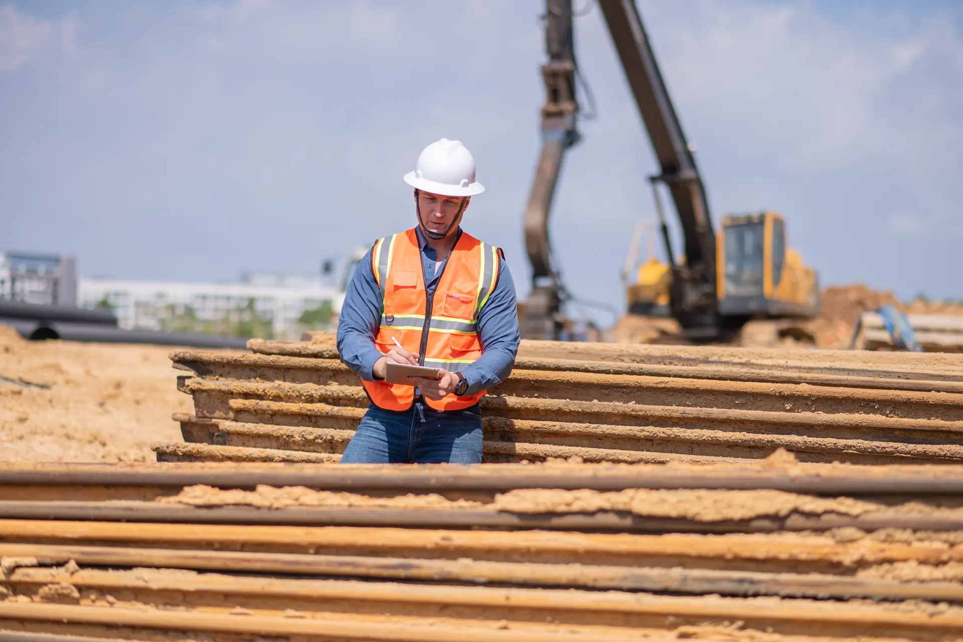 A site supervisor in a high-visibility vest reviewing work on a construction site