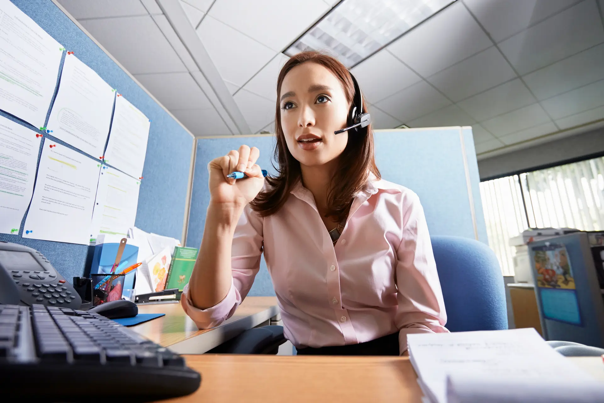 A support agent wearing a headset at a desk